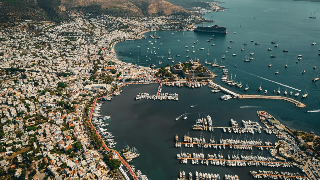 Stunning aerial view of Bodrum harbor showcasing numerous yachts and vibrant cityscape under a clear sky.