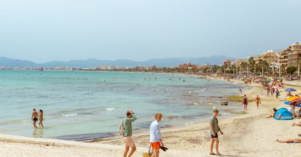 Idyllic summer day at a lively beach in Mallorca with people enjoying the sun and sea.