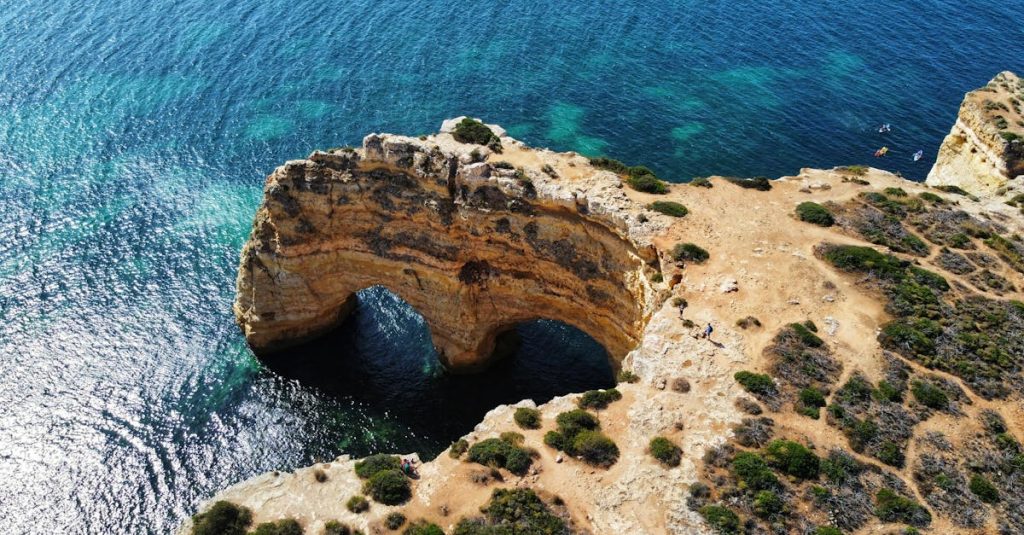 Aerial view of a natural rock arch on the Algarve coast in Lagoa, Portugal.